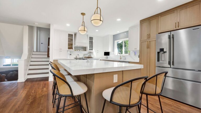 Modern kitchen with island, stainless steel appliances, and wood cabinets.