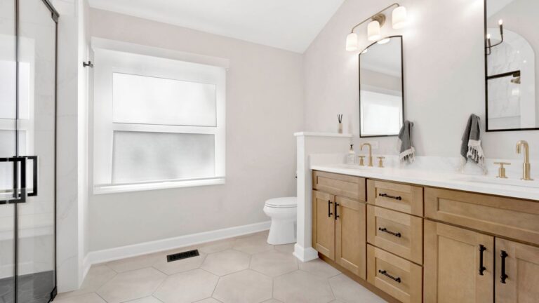 Modern bathroom with double vanity, shower, and toilet.